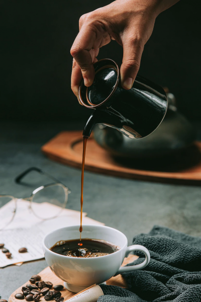 primer-plano-mano-vertiendo-agua-cafe-taza-cafe-concepto-dia-internacional-cafe_1150-25432